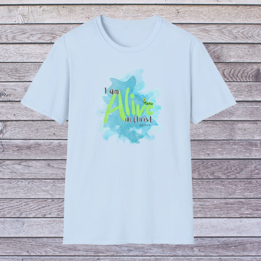 Light blue t-shirt with 'I am Alive in Christ' design on a wooden background