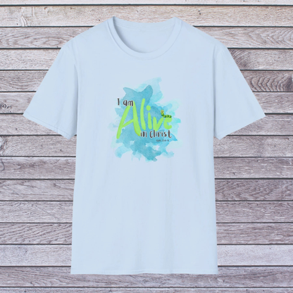 Light blue t-shirt with 'I am Alive in Christ' design on a wooden background