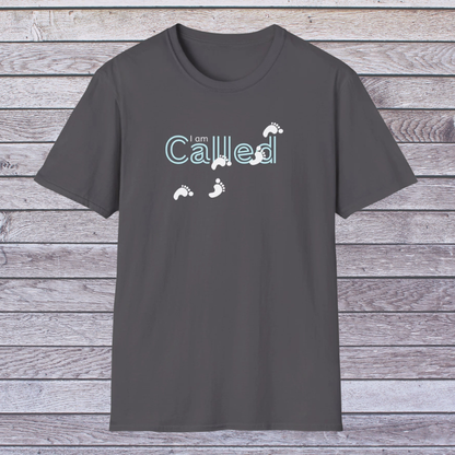 Dark gray t-shirt with 'I am Called' text and footprints on a wooden background