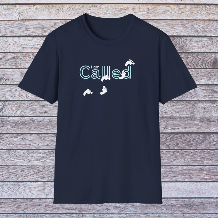 Navy blue t-shirt with 'I am Called' text and footprints on a wooden background