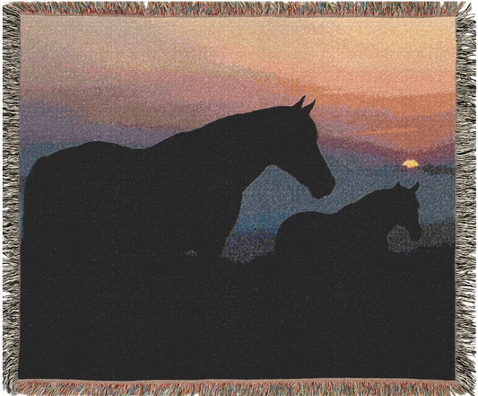 Woven blanket with silhouette of two horses at sunset
