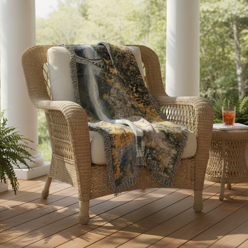 Scenic blanket draped over a brown chair on a porch