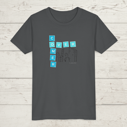 Gray t-shirt with text and graphic design 'Overcomer, 1 John 5:4' on a wooden surface