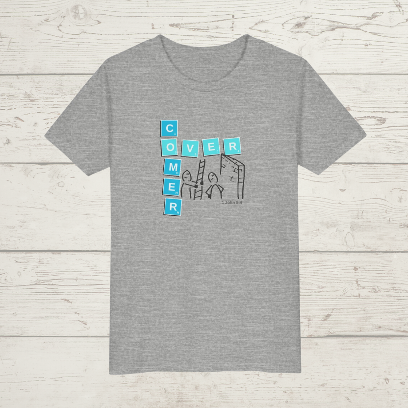 Gray t-shirt with a graphic design 'Overcomer, 1 John 5:4' on a wooden surface