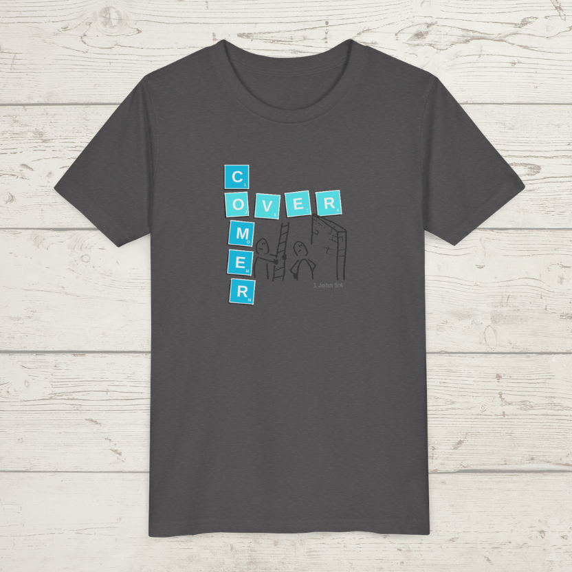 Gray t-shirt with blue and white graphic design 'Overcomer, 1 John 5:4' on a wooden surface