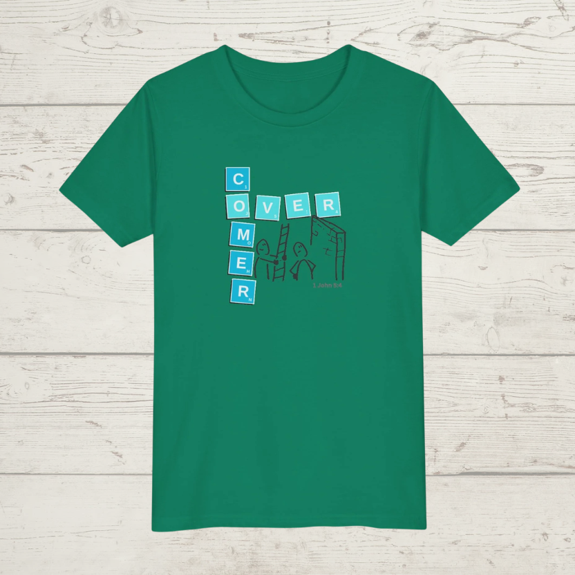 Green t-shirt with a graphic design 'Overcomer, 1 John 5:4' on a wooden surface