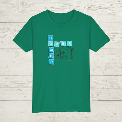 Green t-shirt with a graphic design 'Overcomer, 1 John 5:4' on a wooden surface