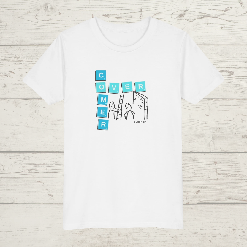 White t-shirt with a graphic design 'Overcomer, 1 John 5:4' on a wooden surface