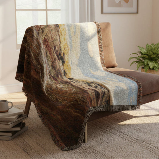 Painted Hill Oregon woven blanket draped over a brown chair in a sunny room