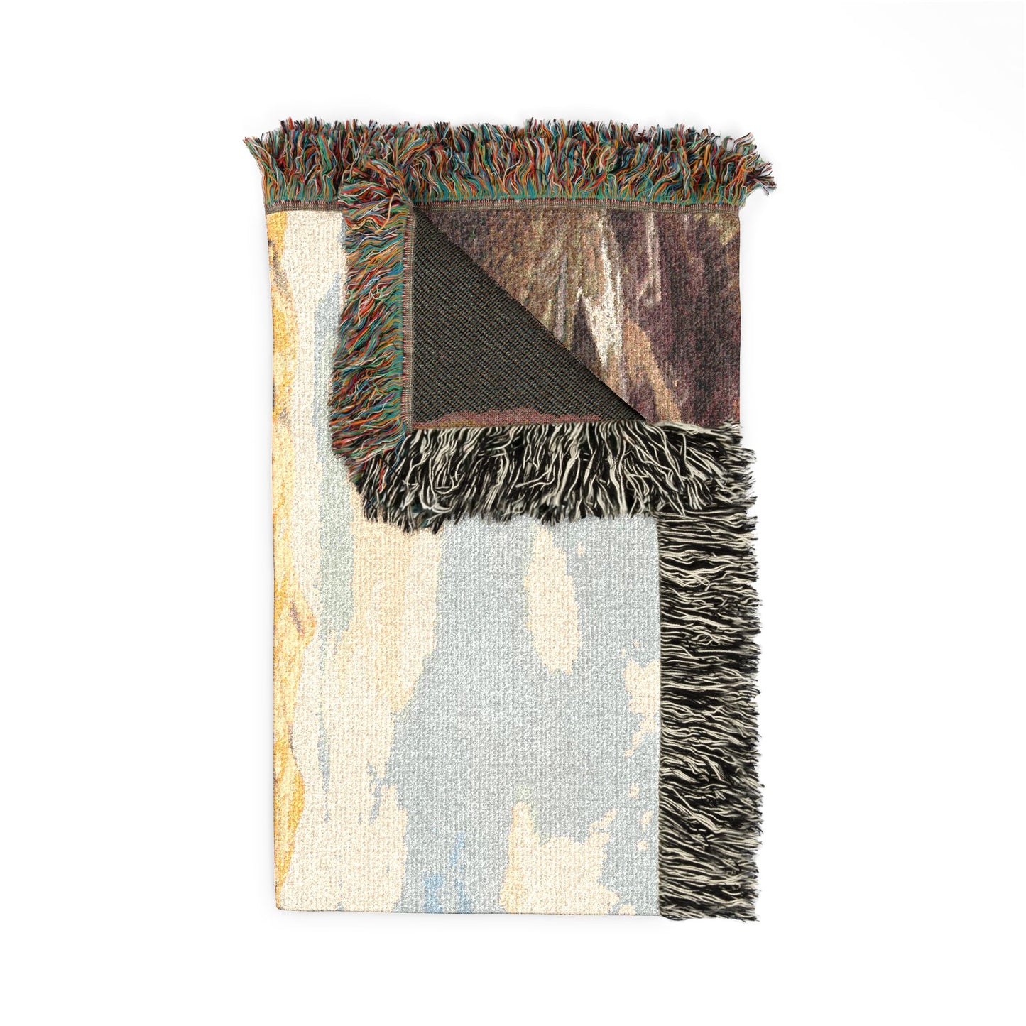 Painted Hills Oregon woven blanket with fringed edges on a white background, folded