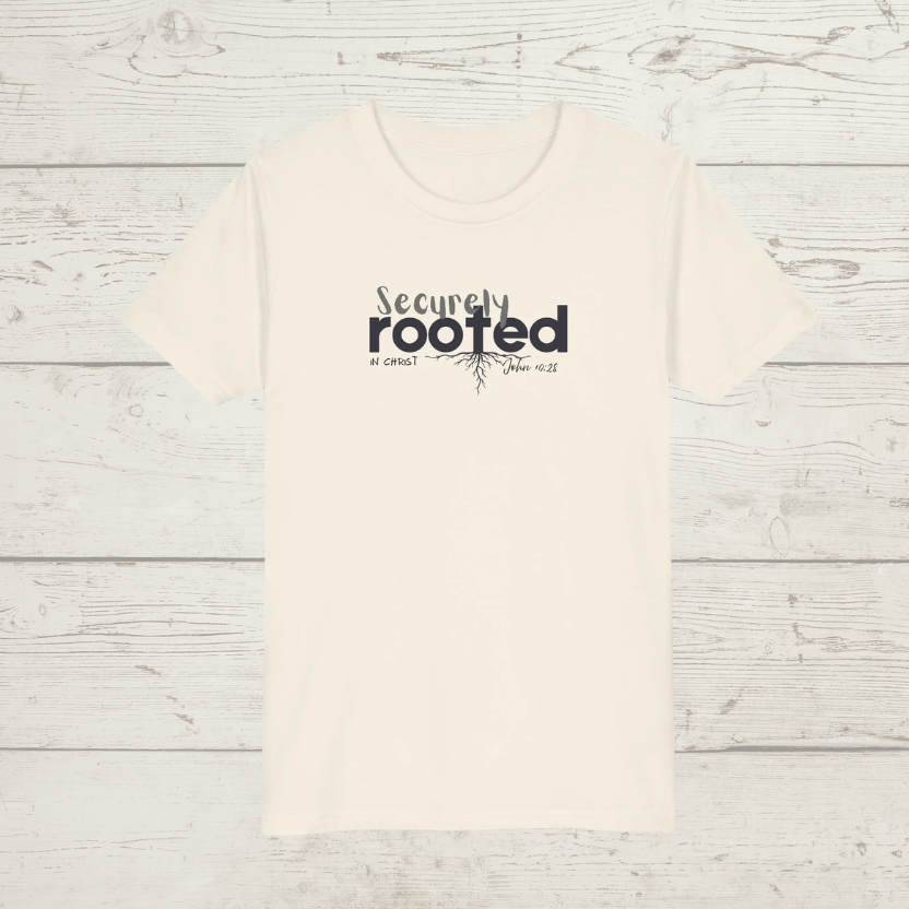 Natural colored t-shirt with white text 'Securely Rooted' on a wood background
