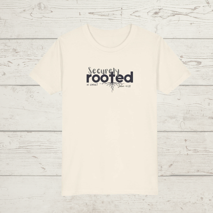 Natural colored t-shirt with white text 'Securely Rooted' on a wood background