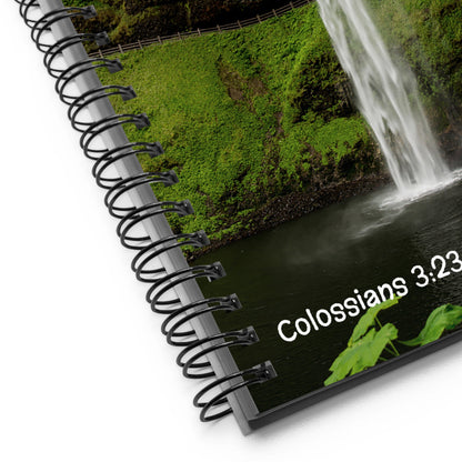 Notebook with a scenic cover featuring a waterfall and text 'Colossians 3:23'.