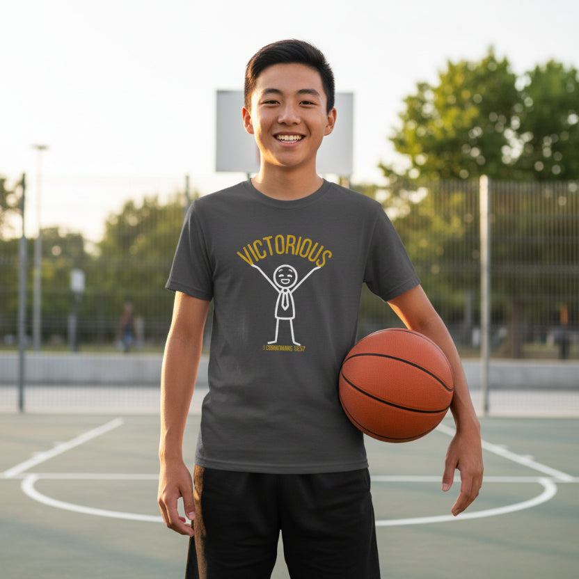 Dark gray t-shirt with 'Victorious' graphic design holding basketball outside