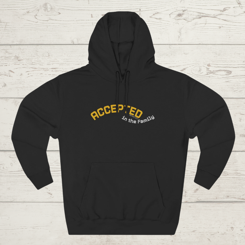 Black hoodie with 'ACCEPTED in the Family' text on a wooden surface