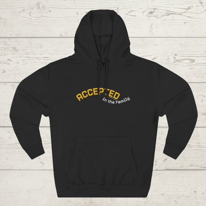 Black hoodie with 'ACCEPTED in the Family' text on a wooden surface