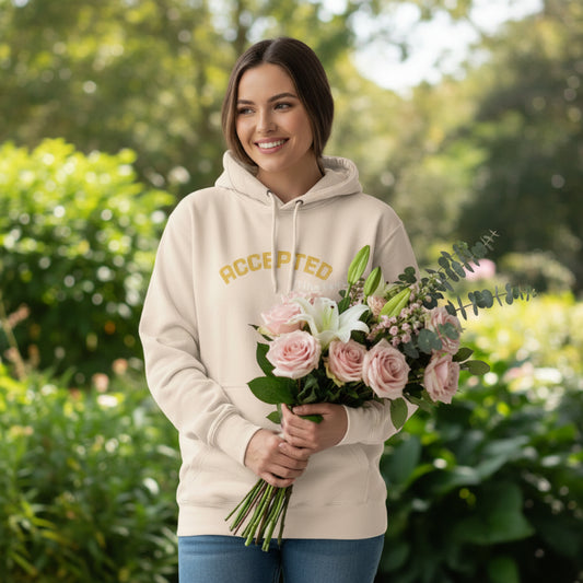 Pale Pink hoodie with 'ACCEPTED in the Family' text in yellow holding bouquet of flowers