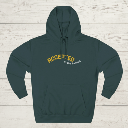 Green hoodie with 'ACCEPTED in the Family' text on a wooden surface