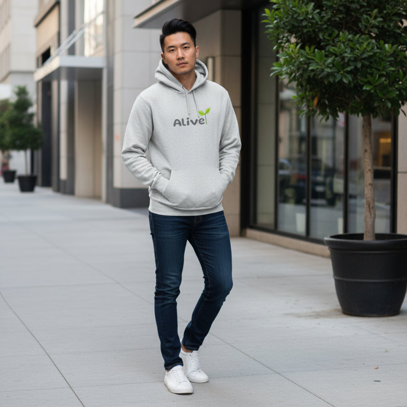 Gray hoodie with 'Alive' logo on town sidewalk