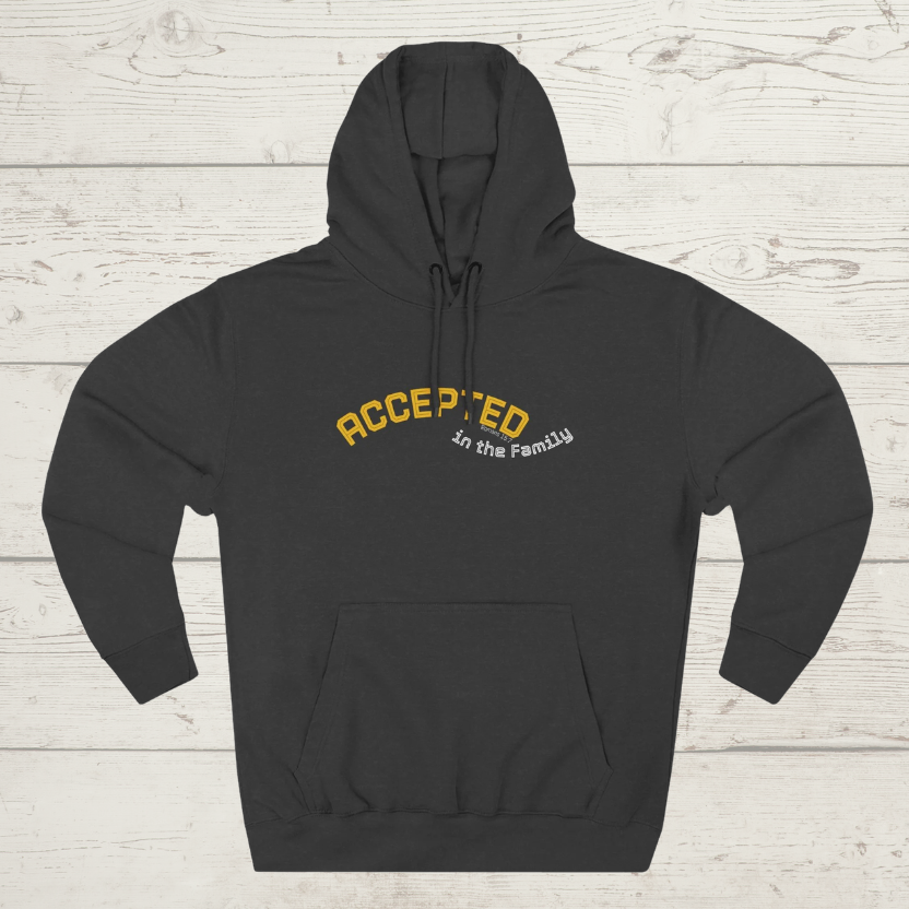 Charcoal heather hoodie with 'ACCEPTED in the Family' text on a light wooden background