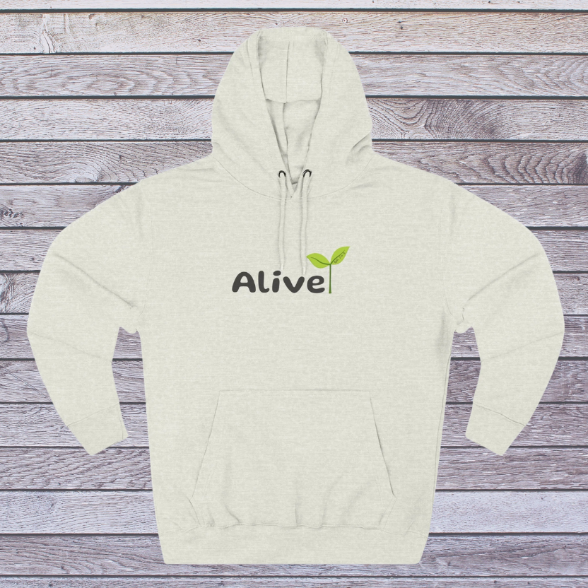 Oatmeal Beige hoodie with 'Alive' text and green leaf graphic on a wooden surface