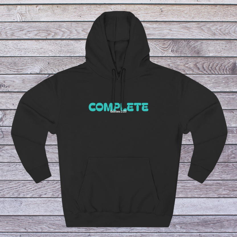 Black hoodie with teal 'COMPLETE' text on a wooden surface