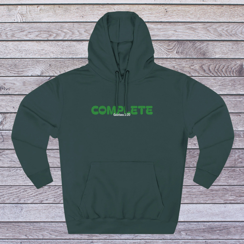 Green hoodie with 'COMPLETE' text on a wooden surface