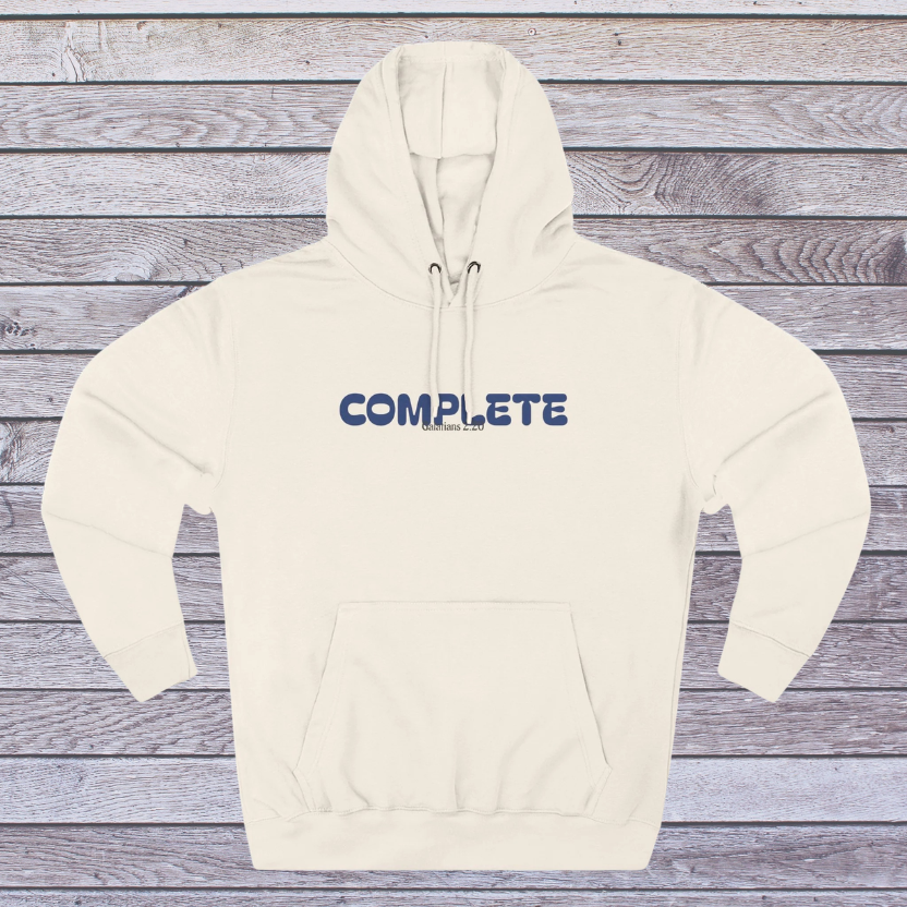 Beige hoodie with 'COMPLETE' text on a wooden surface