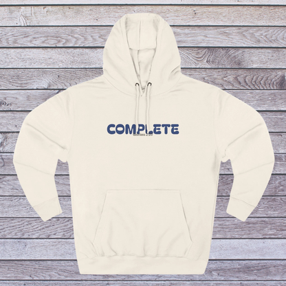Beige hoodie with 'COMPLETE' text on a wooden surface