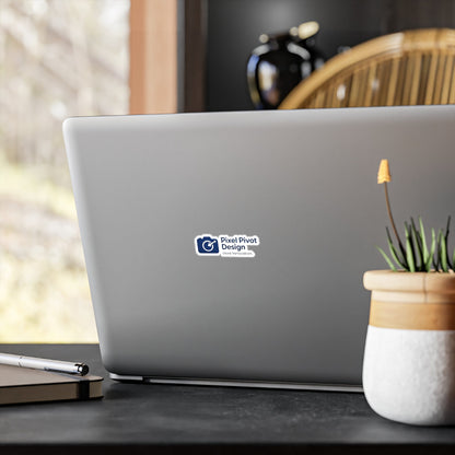 Laptop with a sticker on a desk with a plant and pen