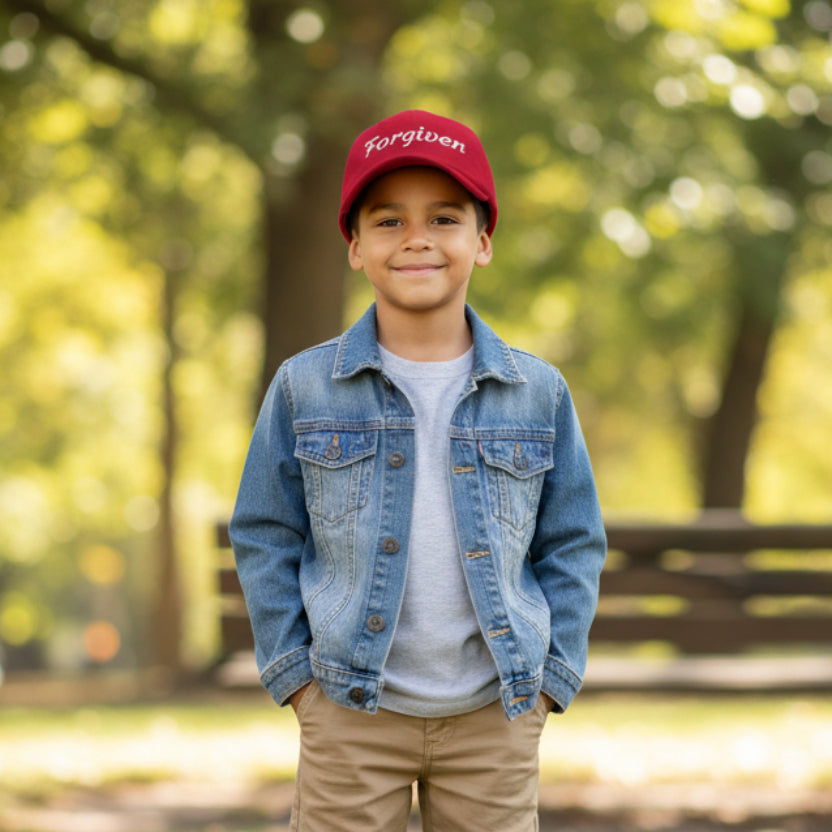 Red cap with 'Forgiven' embroidered boy outside in the park
