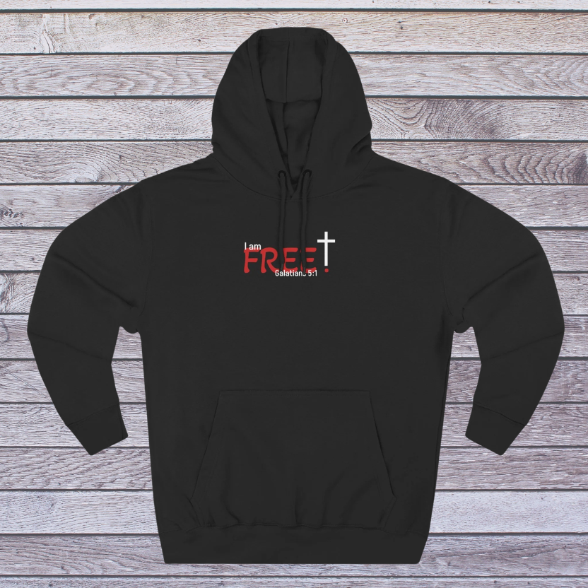 Black hoodie with red and white text 'I am free, Galatians' on a wooden surface