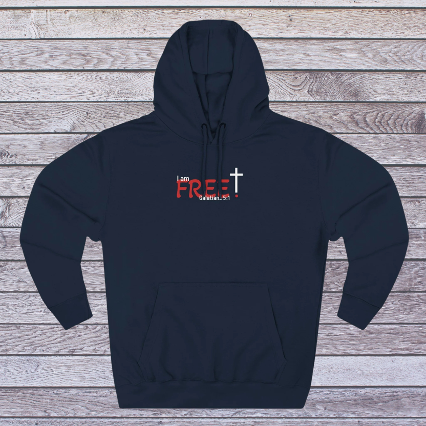 Black hoodie with red and white text and cross on a wooden surface, 'I am free, Galatians'