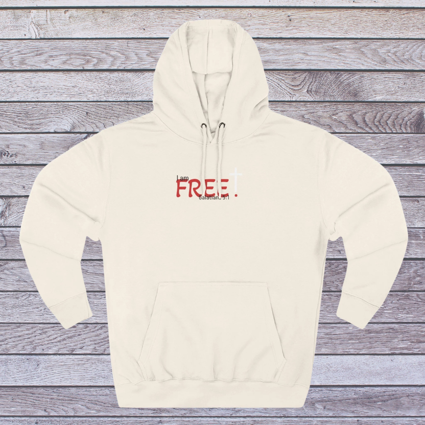 Sand shell hoodie with red text on a wooden surface, 'I am free, Galatians'