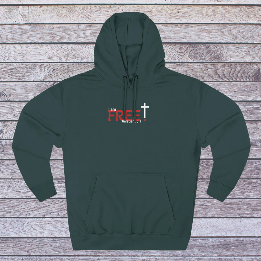 Green hoodie with text and cross design on a wooden background