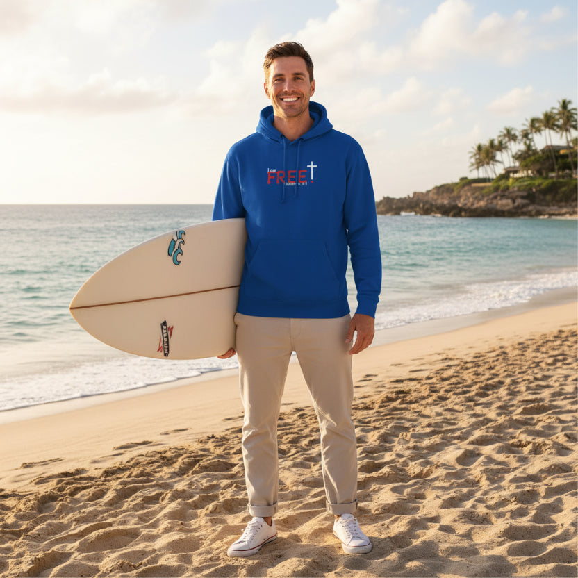 Blue hoodie with a red and white logo 'I am free, Galatians' at the beach with surfboard