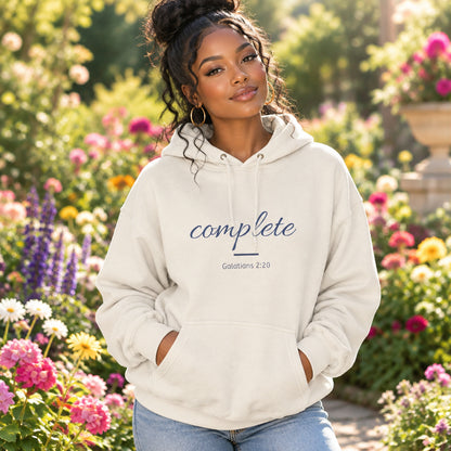 A cream natural hoodie features the word 'complete' in blue cursive script and 'Galatians 2:20' in smaller black text on the chest.