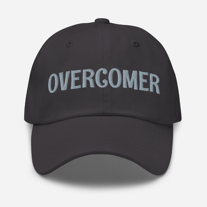 Dark grey cap with 'OVERCOMER' text on a light gray background
