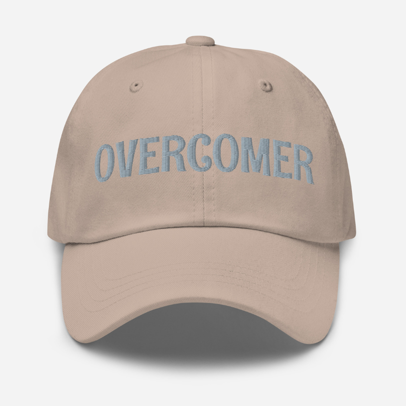 Stone Beige cap with 'OVERCOMER' embroidered on a white background
