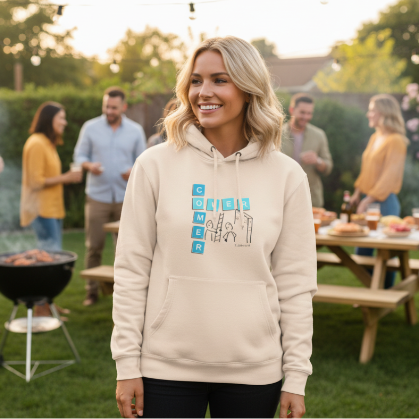Sand Shell Beige hoodie with 'Overcomer, 1 John 5:4' graphic design at a BBQ with friends