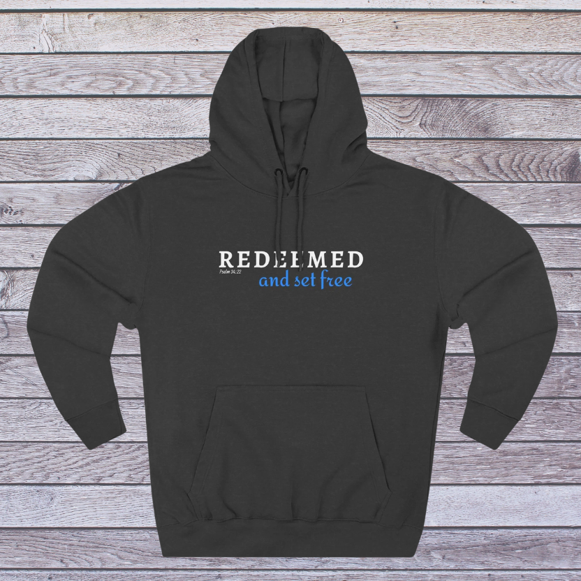 Charcoal Heather grey hoodie with 'REDEEMED and set free' text on a wooden background