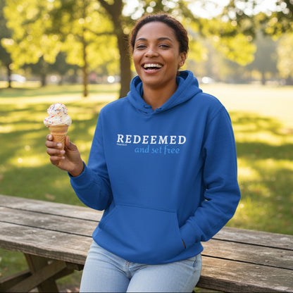 Blue hoodie with text 'REDEEMED and set free' at the park holding an ice cream cone, Psalm