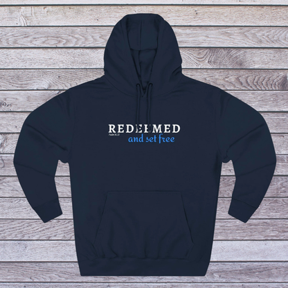 Navy hoodie with 'REDEEMED and set free' text on a wooden background
