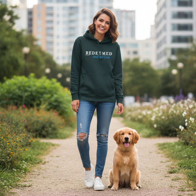 Green hoodie with 'REDEEMED and set free' text, with cute puppy in city garden scene