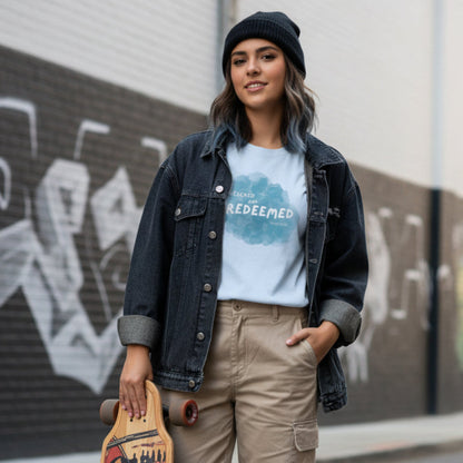 Light blue t-shirt with a 'Rescued and Redeemed' graphic, worn by streetwear female with longboard