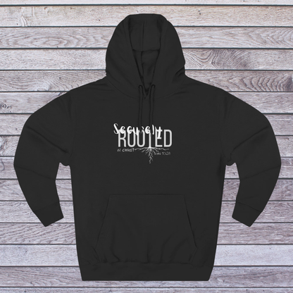 Black hoodie with white text 'Securely Rooted' on a wooden background