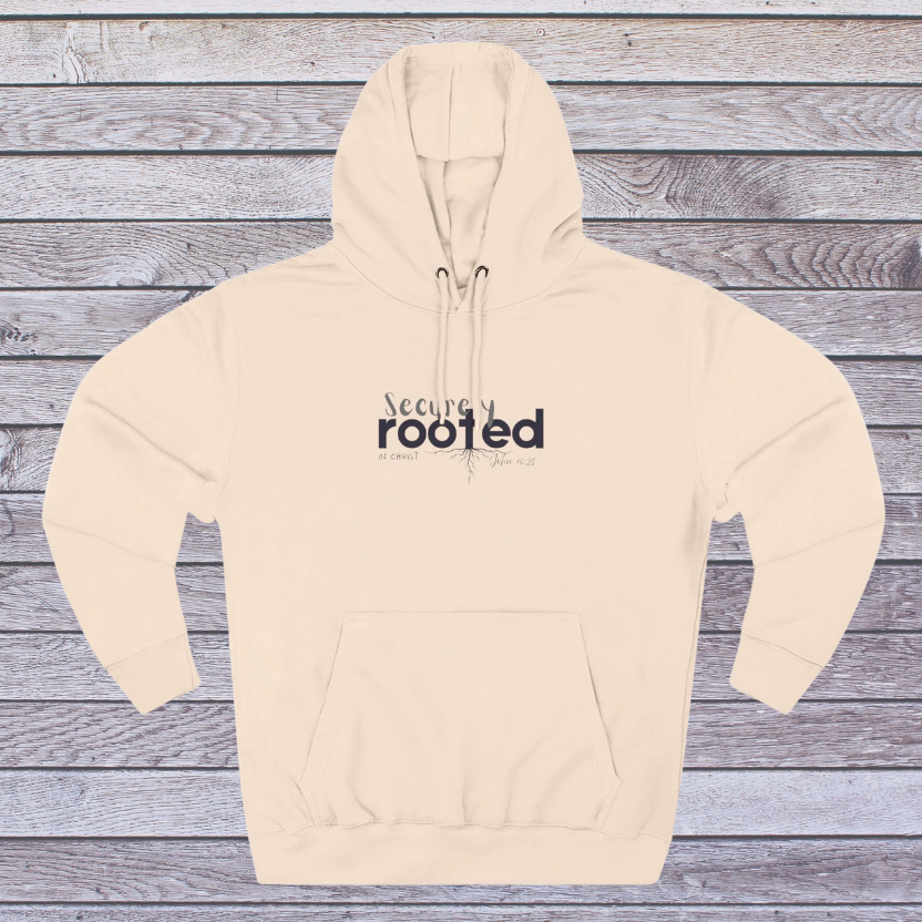 Pale Pink Beige hoodie with 'Securely Rooted' text on a wooden background
