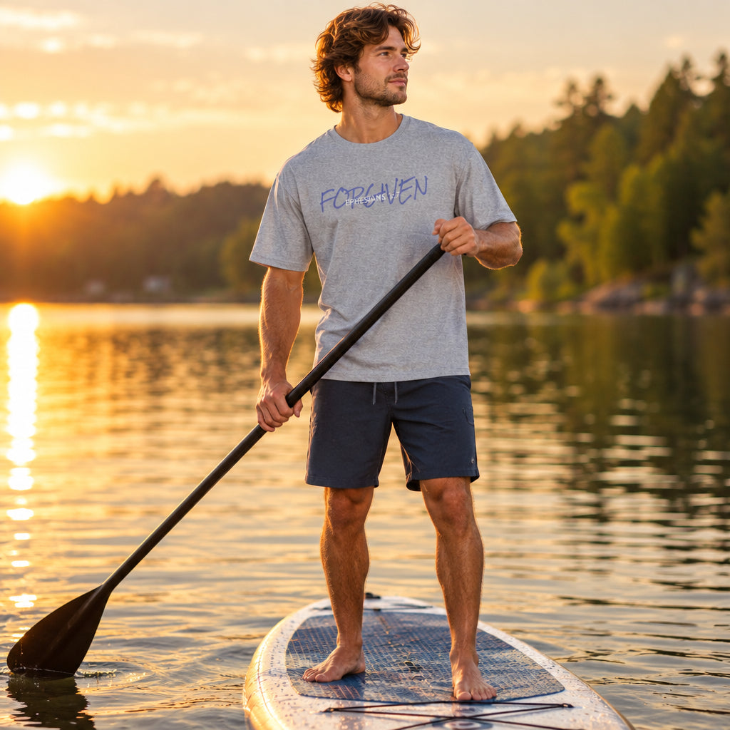 Person paddle-boarding wearing a gray t-shirt with text 'forgiven'