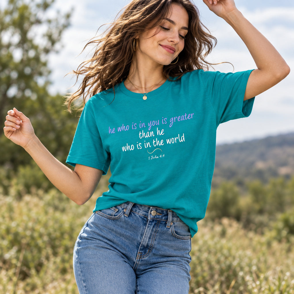 Person wearing a teal t-shirt with verse of 1 John 4:4