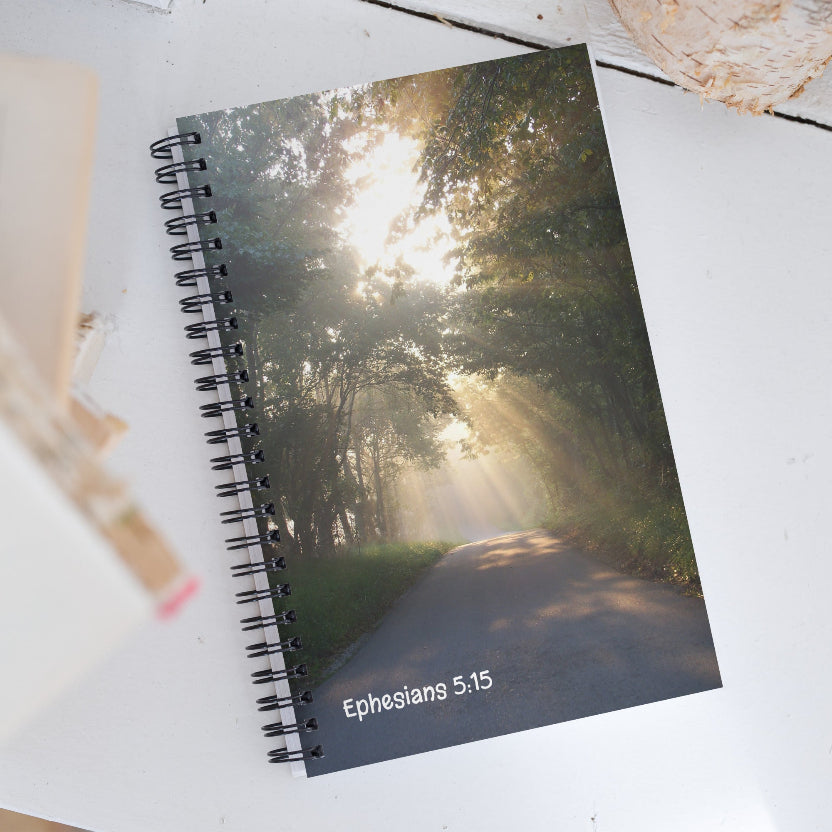 Notebook with a forest design and 'Ephesians 5:15' text on a white surface